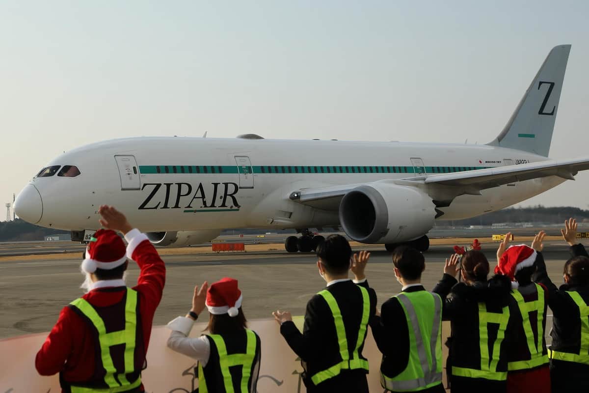 ZIPAIR（ジップエア）のロサンゼルス行き初便は53人が搭乗。西田真吾社長（左端）ら関係者がサンタクロース姿で見送った
