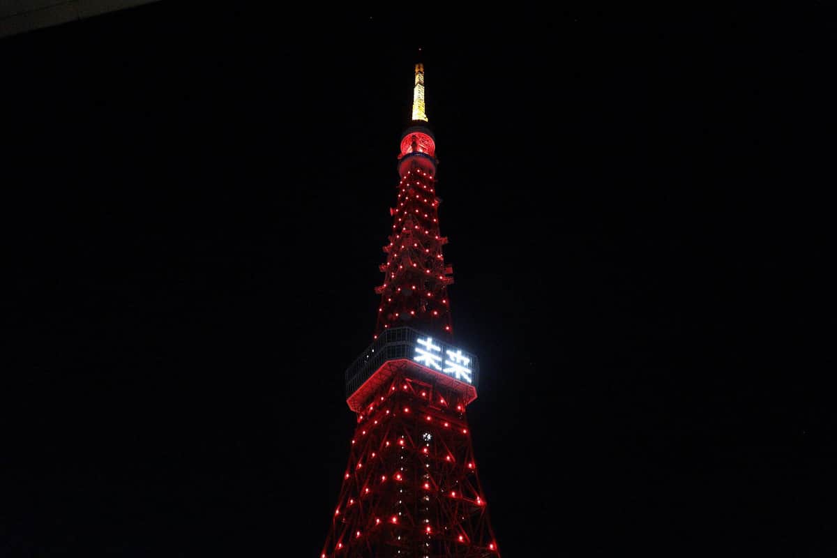 赤くライトアップされた東京タワー。展望台メインデッキの窓にはLEDで「未来」の2文字が投影された