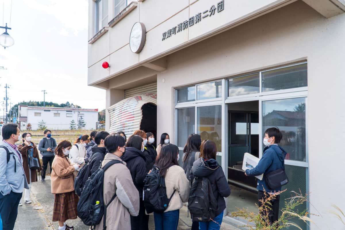 「双葉タウンストーリーツアー」で、消防団屯所前でのストーリー紹介（写真提供：F-ATRAs）