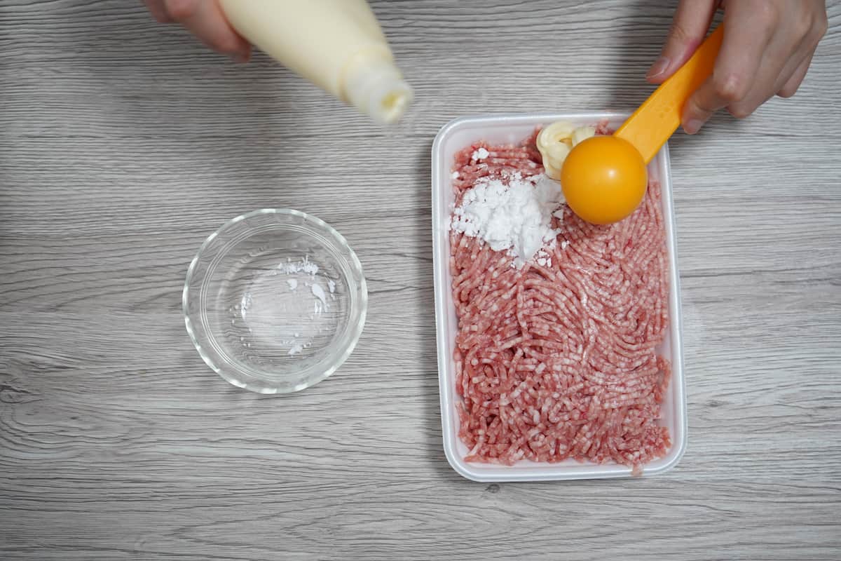 ひき肉をパックに入れたまま、片栗粉とマヨネーズを加えてよく混ぜる