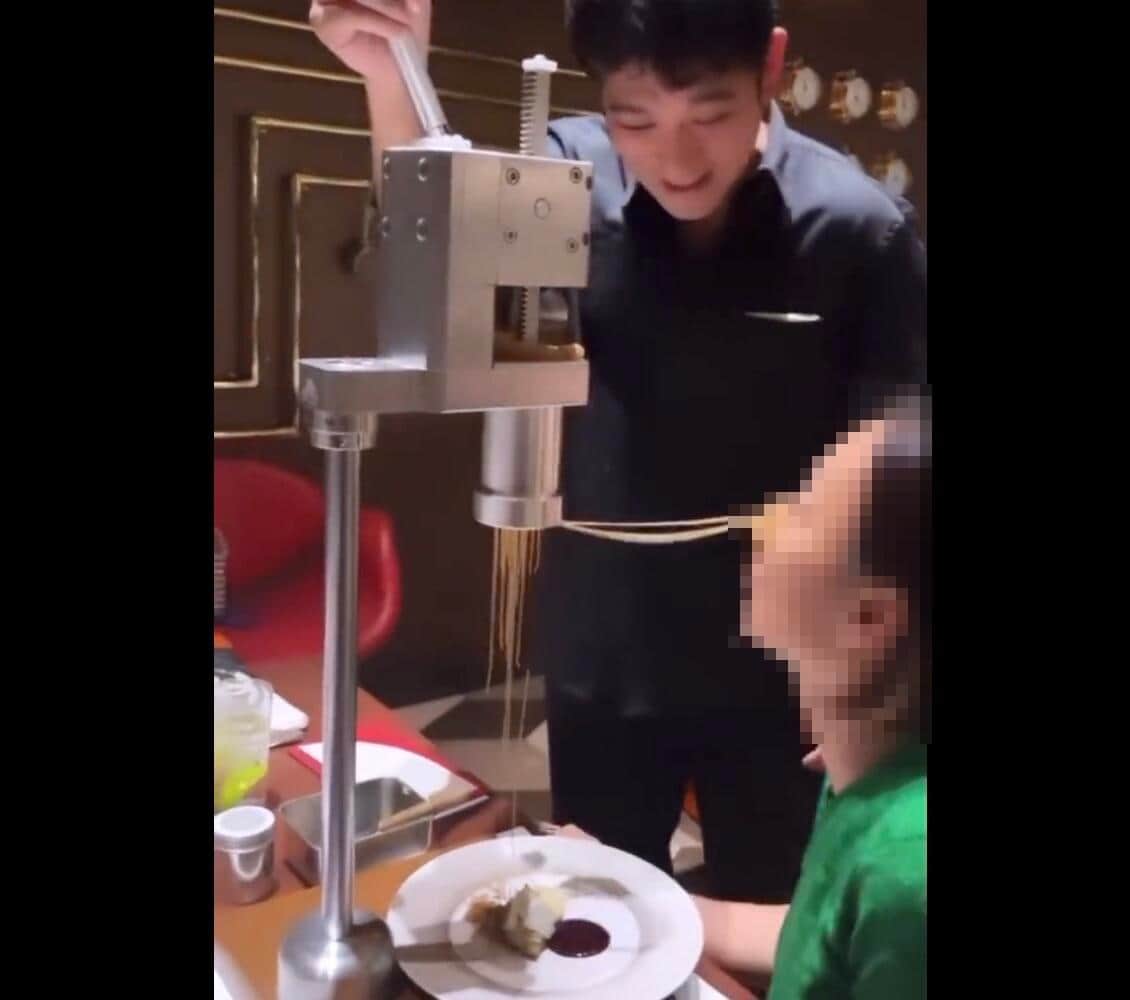 須賀氏が客の顔面にモンブランを絞っている（SNS上で拡散された動画より） 