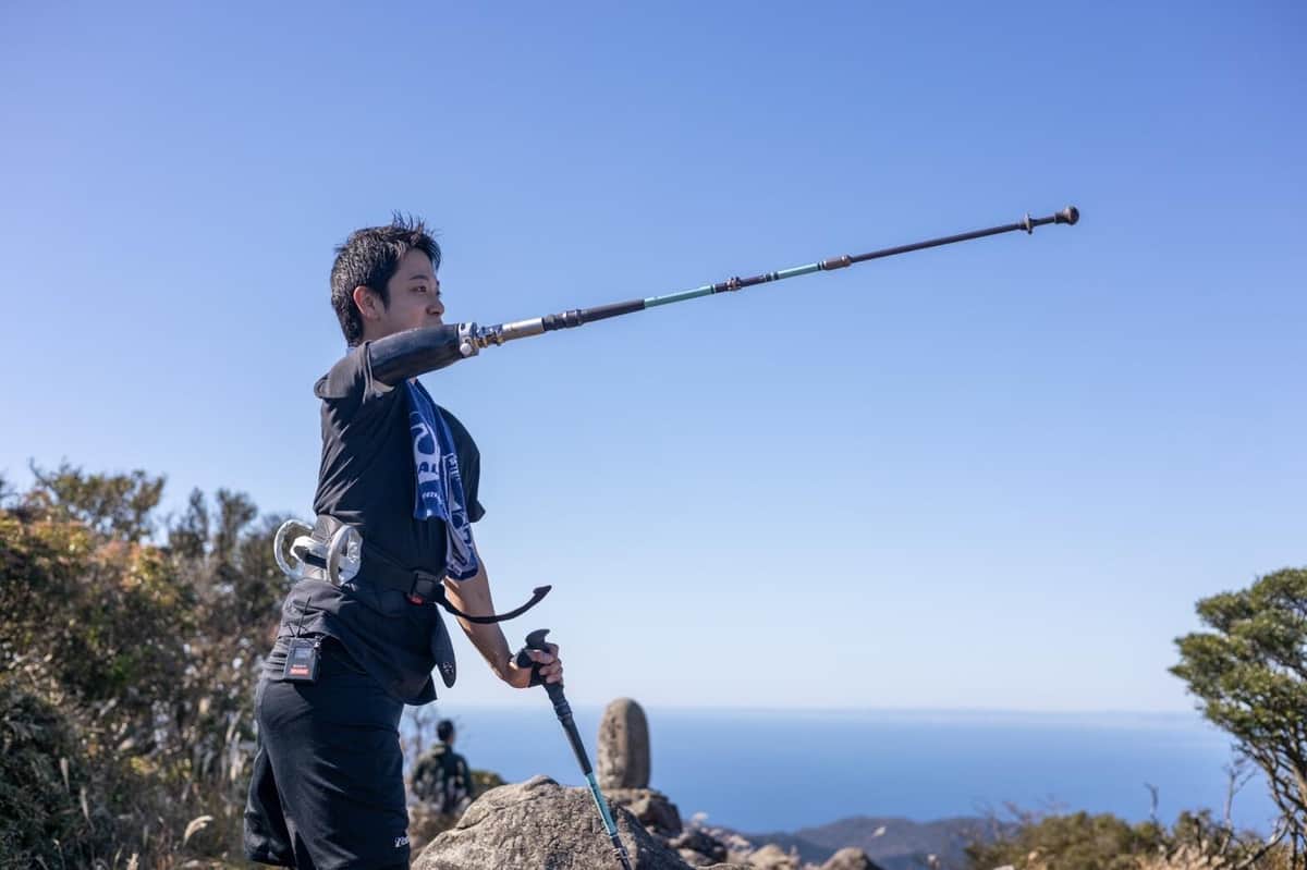 ストックつきの義手を使って金冠山に登った山田千紘さん