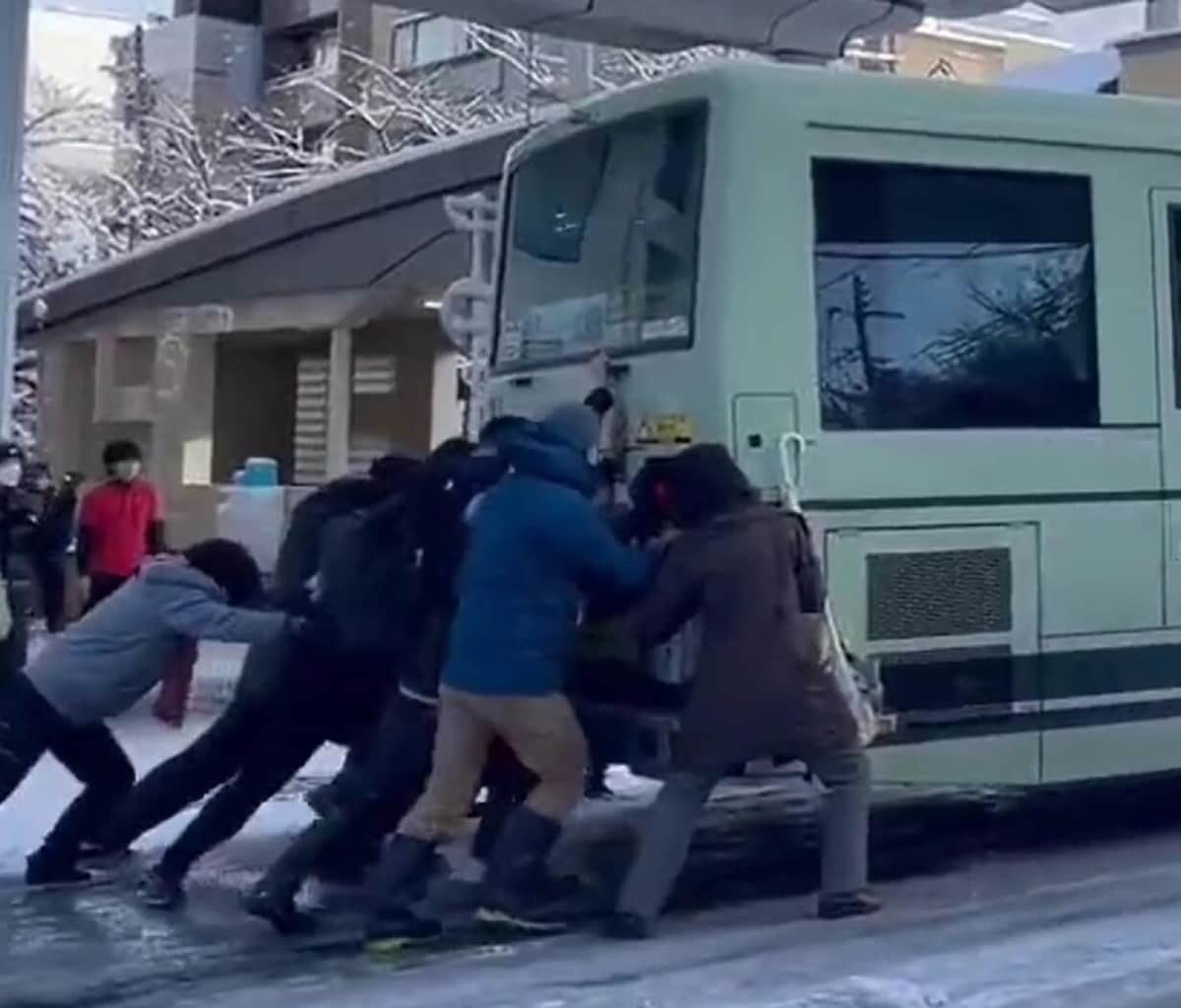 バスを懸命に押す通行人ら（ツイッター投稿の動画から）