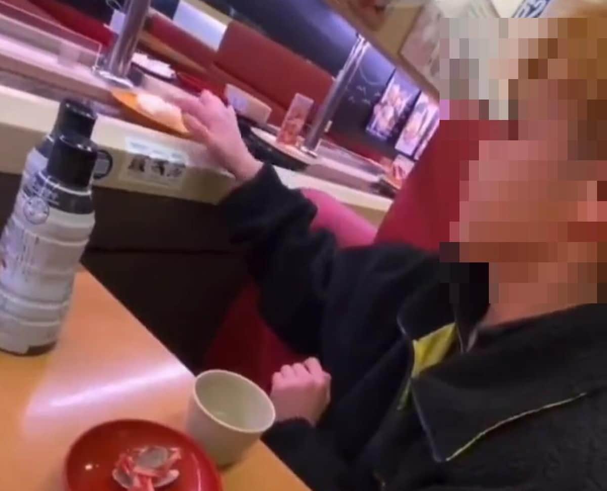 なめた指で寿司のネタに触る男性（投稿された動画から）