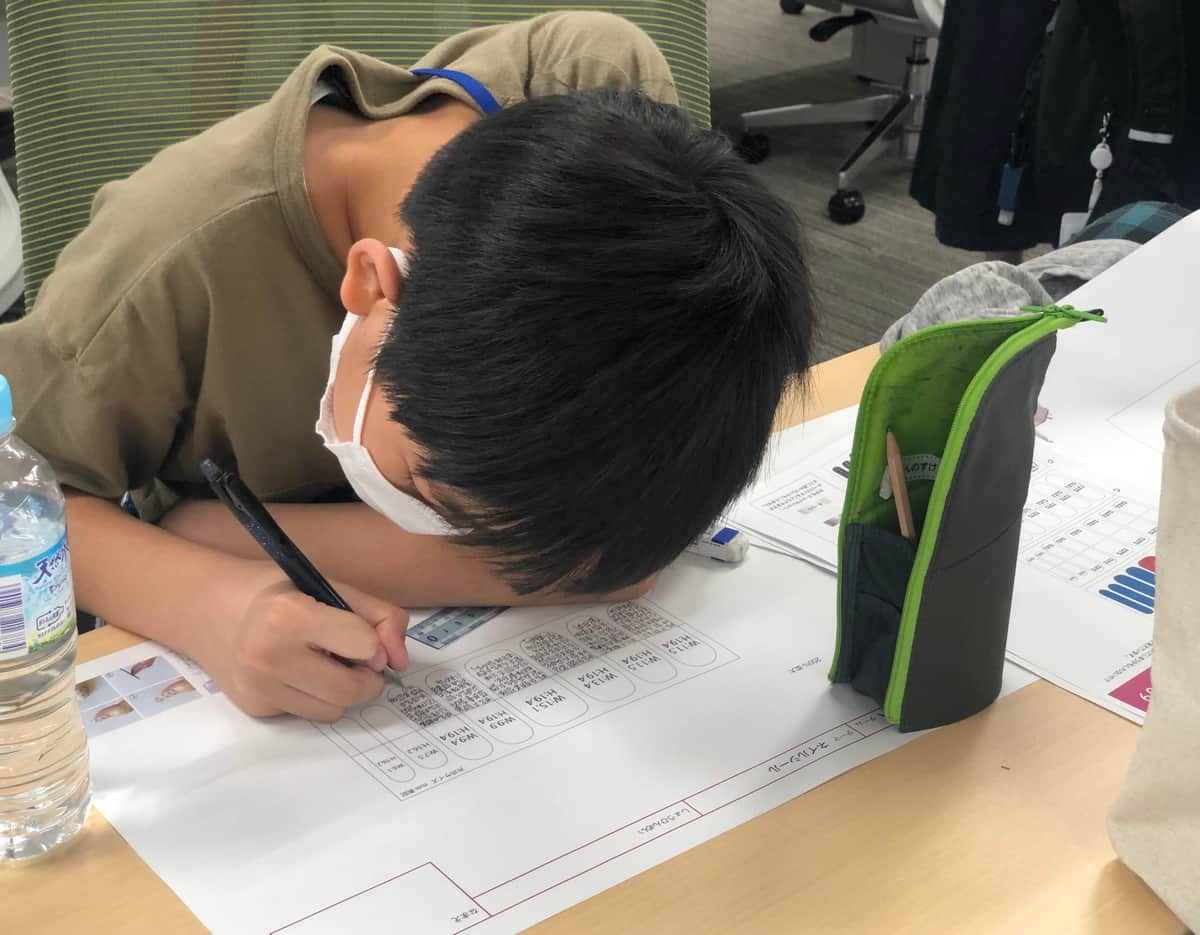 九字護身ネイルシールの企画書を書く姿（写真提供：ツイッターユーザー＠dkuniiさん）