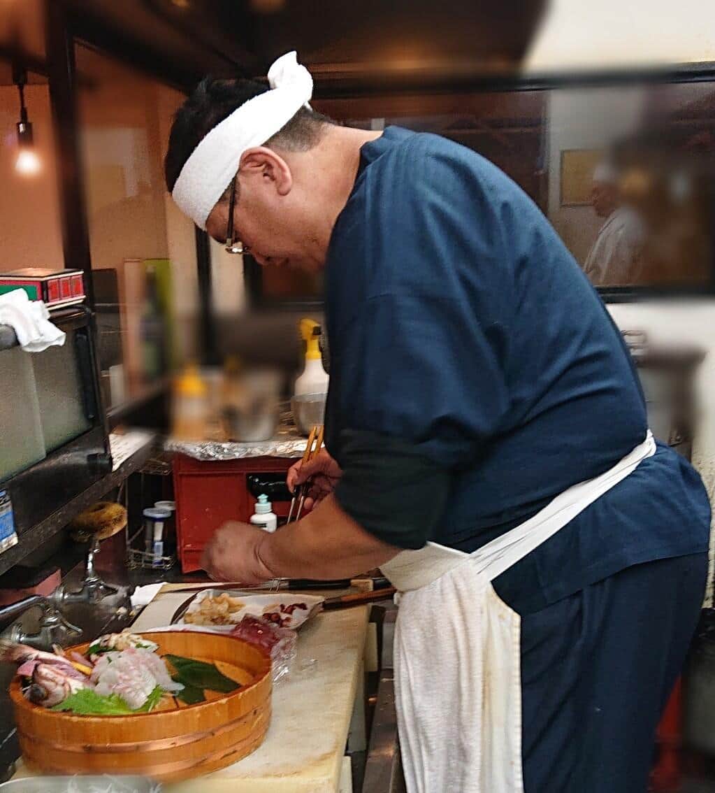 厨房で料理をする平井氏