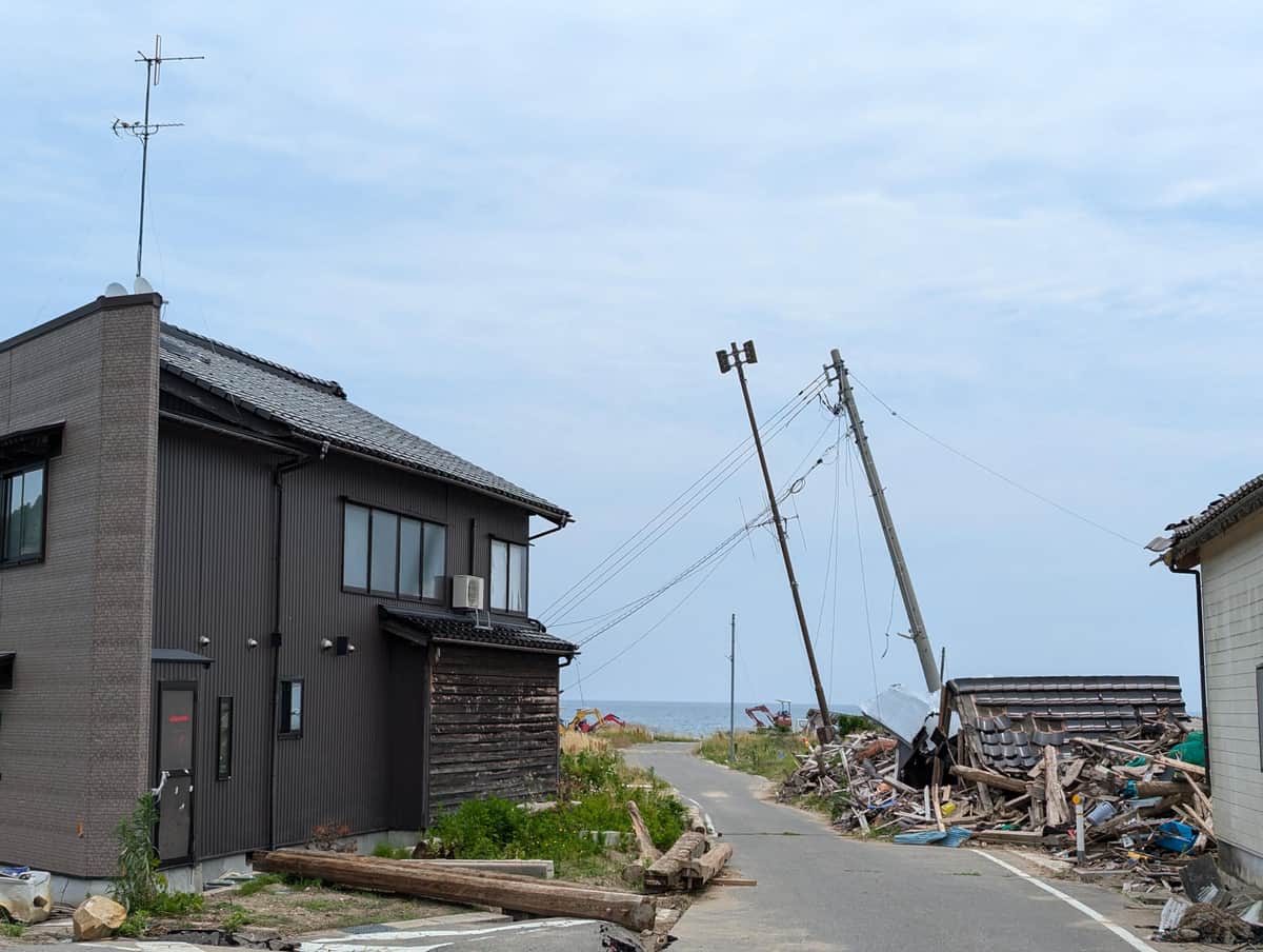 電柱も傾いたまま。奥に海が見える