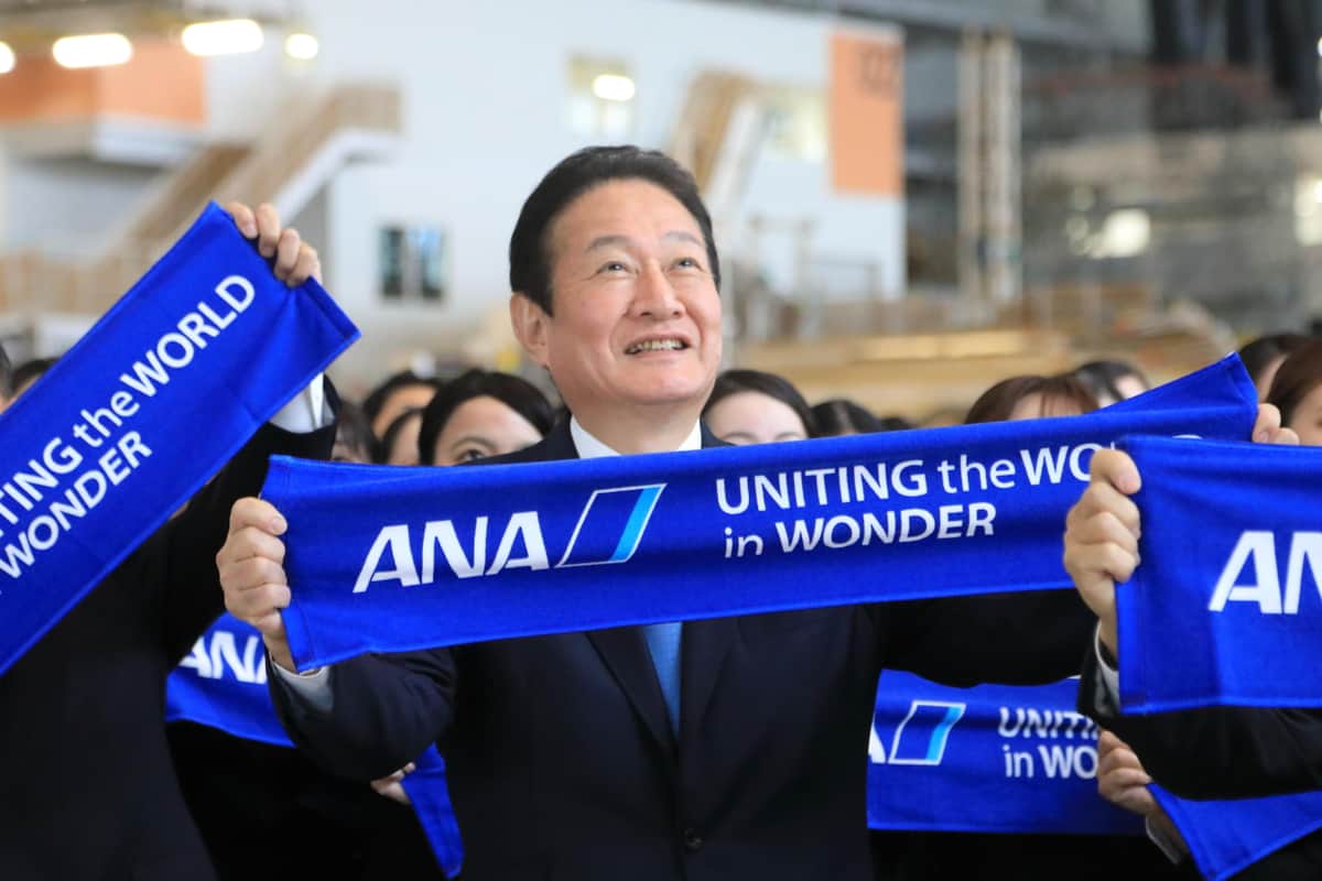 カメラを前に笑顔を見せるANAの井上慎一社長