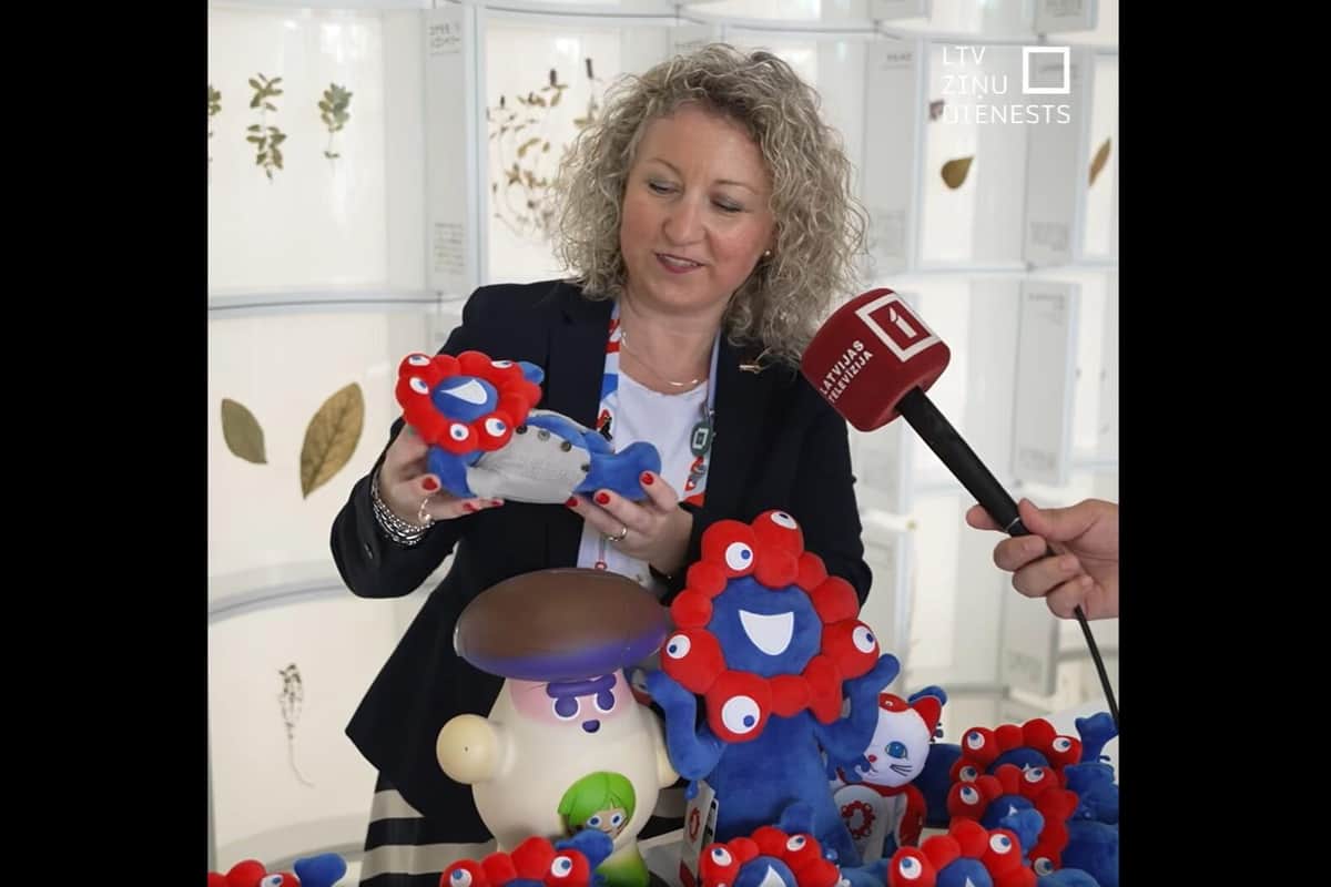 服を着たミャクミャクもプレゼントされたという（写真はラトビア国営テレビのフェイスブックページから）