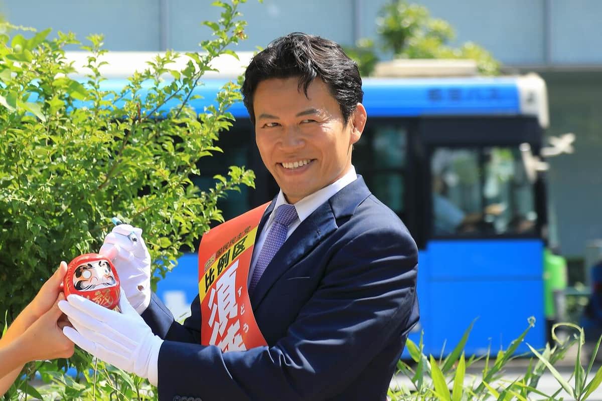 須藤氏はだるまの片目に墨を入れた