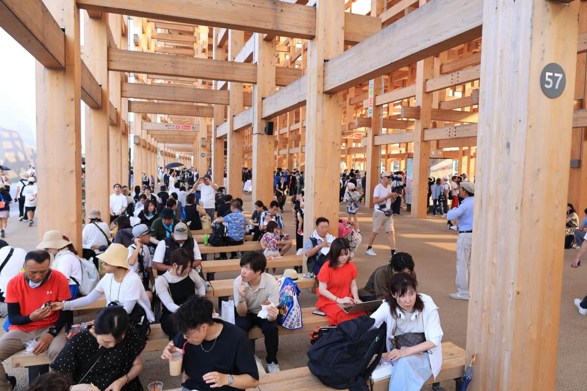 大屋根リングの下で休憩する人々