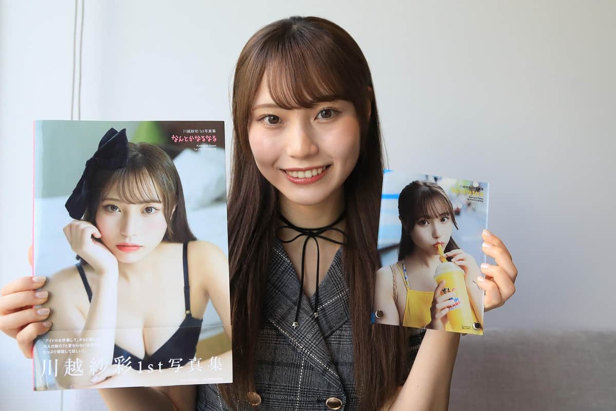 写真集とアクリルフォトプレートを手に取材に応じる川越紗彩さん