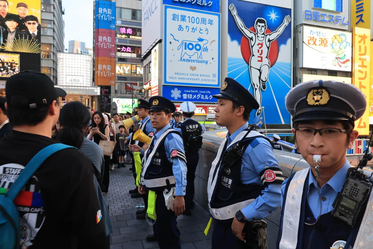 戎橋で橋の端に近づかないように警戒する警察官（7日、大阪市中央区）
