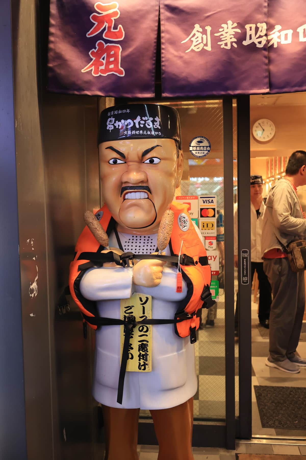 救命胴衣を着せられた「串かつだるま」の「だるま大臣」