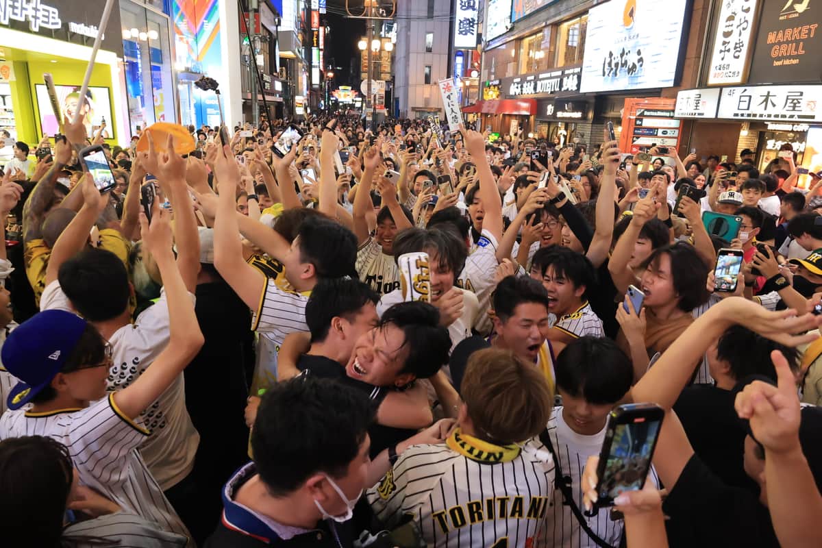 阪神の優勝を喜んで抱き合うファン（7日、大阪市中央区）