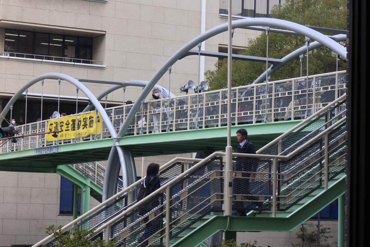 記者会見室に向かって歩道橋でデモの準備が行われていた（2025年12月10日撮影）