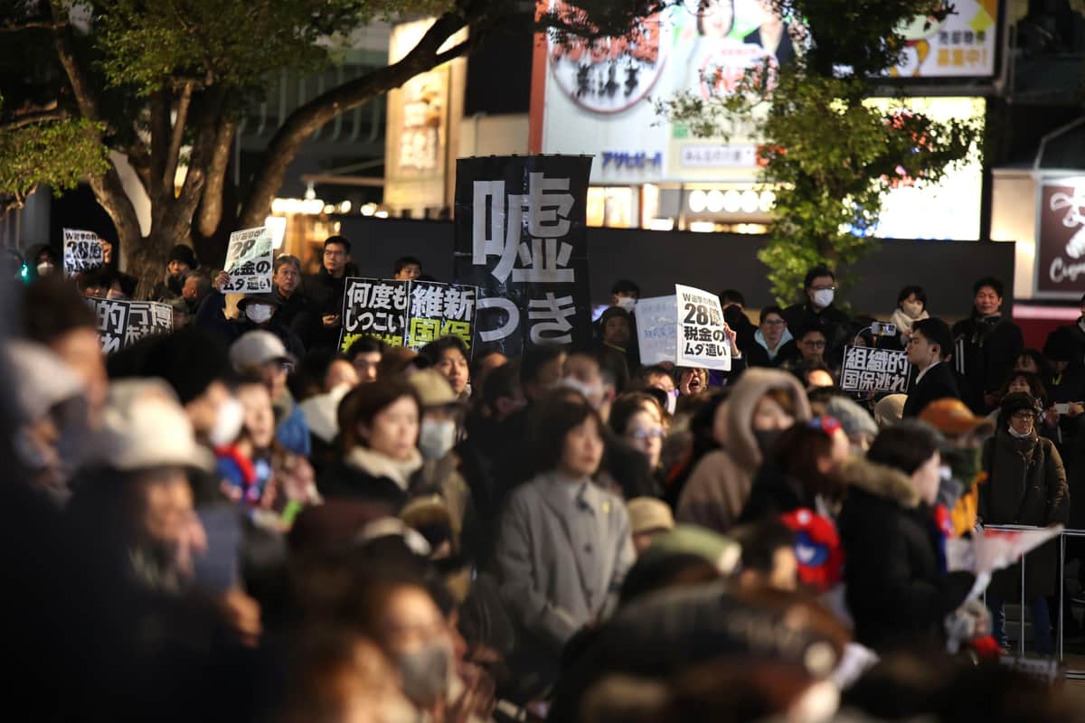 演説に対して抗議のプラカードを掲げる人々（2月7日、大阪・なんば）