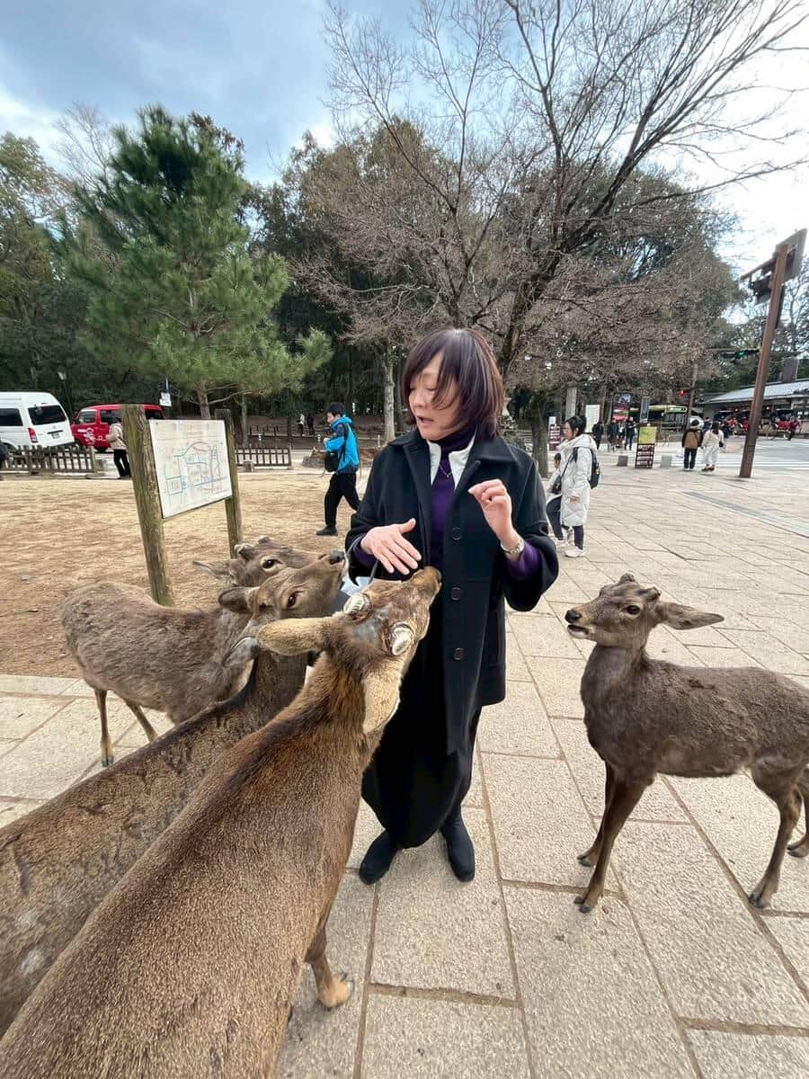 シカにえさをあげる安倍昭恵さん。微妙な表情だ（安倍昭恵さんのXから）