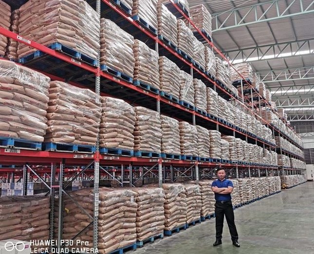タイの倉庫で小麦粉の前に立つ原五大さん（本人提供）