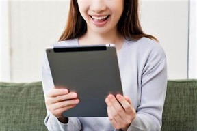 タブレット端末でゲームを楽しむ（写真はイメージ）