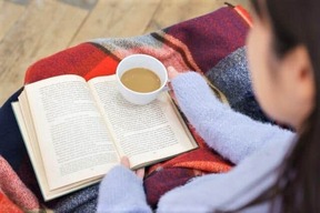 飲み物を手に読書のひととき（写真はイメージ）