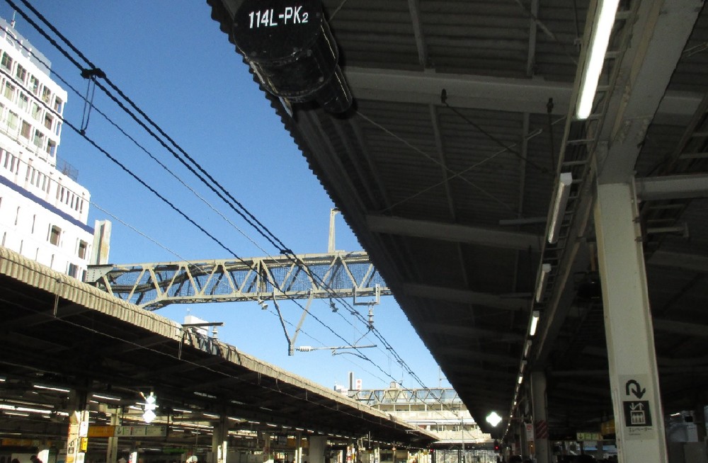 同じ駅でも、全部の蛍光灯をつけているホーム（向こう側）と、3本のうち2本を消しているホーム（手前）。（東京のJR池袋駅で）