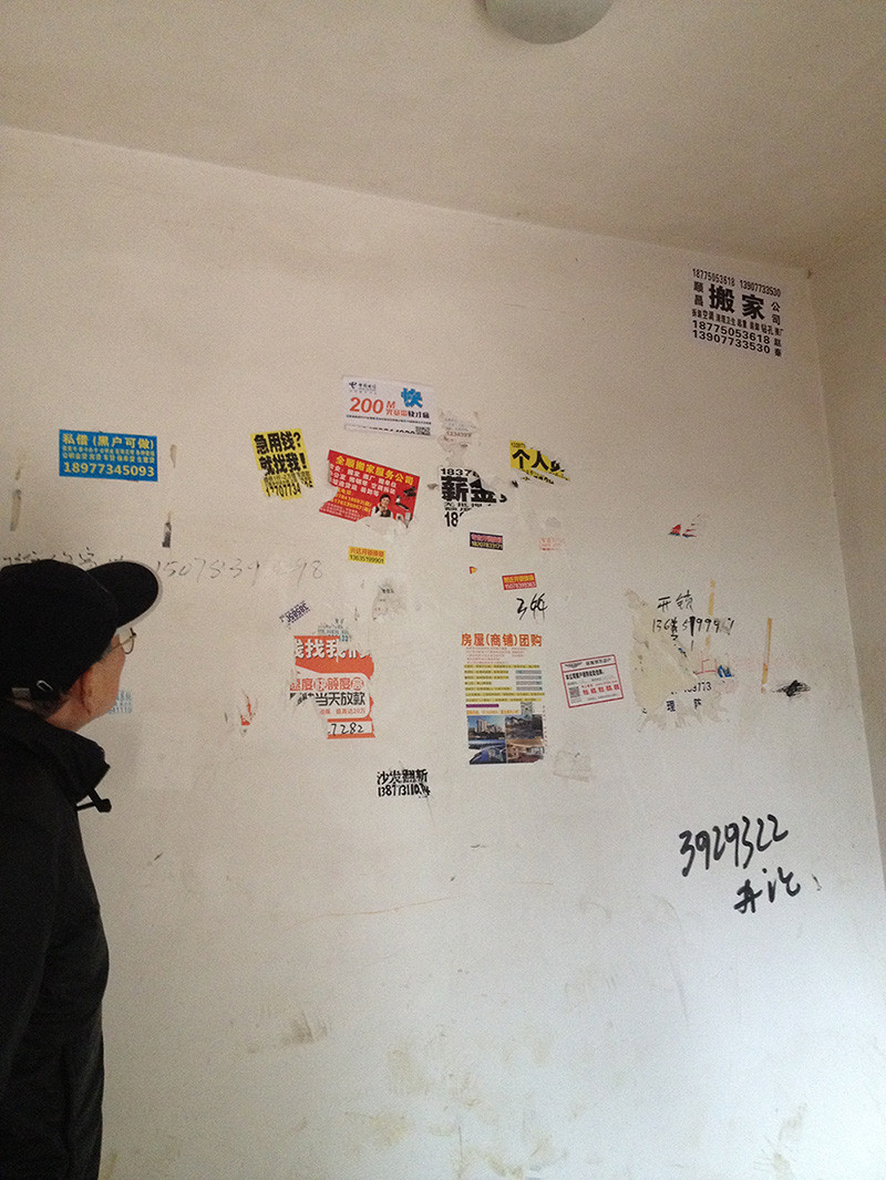 アパートの階段の白壁を汚している広告（中国・広西の桂林市で）
