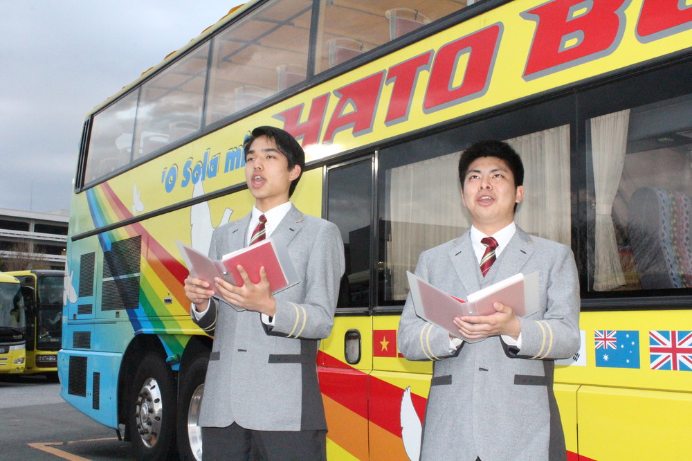 バスの前で発声練習をする三國蘭さん（左）と松尾龍治さん（東京・平和島のはとバス本社で）