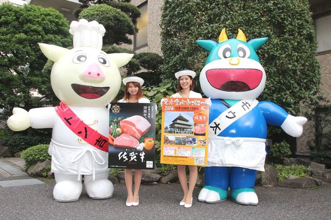 「まつり」キャンペーンのためJ-CASTニュースを訪れた東京食肉市場マスコットキャラクター、トン吉とモウ太、佐賀市観光キャンペーンレディの白井夏海さん(左)と木塚由梨絵さん。モウ太もトン吉も、木塚さんと白井さんも当日は会場で来場者をアテンドする