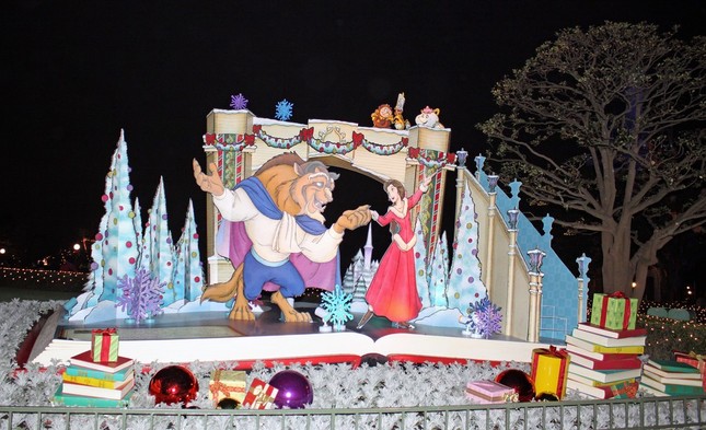 TDL、シンデレラ城前プラザに飾られた「美女野獣」のデコレーション。ベルとビーストがスケートを楽しんでいるシーンの周りにプレゼントの本などが置かれている