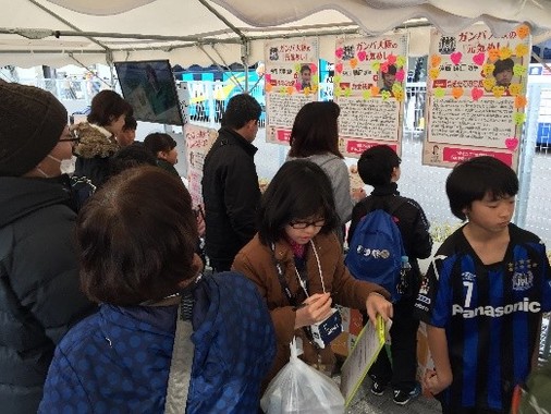 遠藤保仁選手らG大阪3選手の「元気めし」についての寄せ書きを熱心に読むサポーターら