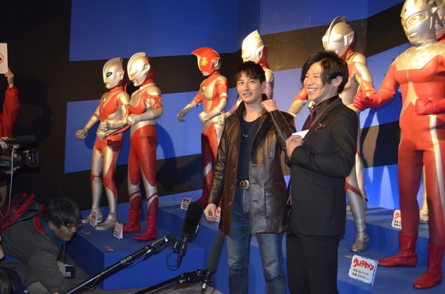 歴代ウルトラヒーローの立像の前でインタビューに応じる、ゲストの2人