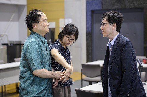 指点字通訳者は、任龍在准教授（右）の言葉や表情、引率した韓国の学生たちの雰囲気までも福島教授に伝えていた