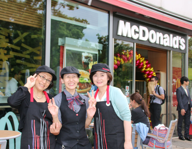 「主婦向けクルー体験会」に参加した主婦（写真左右）と、マクドナルドのクルー（中央）