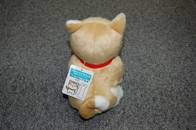 しっぽはくるりんと丸まっている。タグは紙のネームプレートのようだ