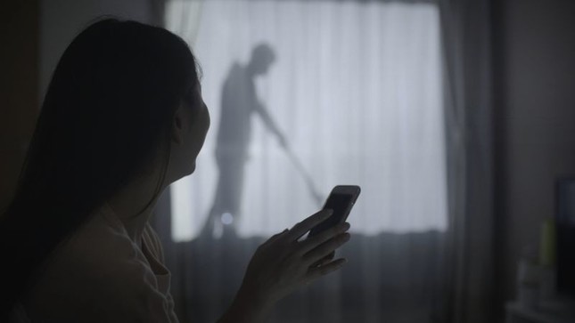 カーテンに男性のシルエットが映る