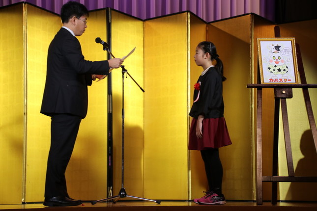 （左から）農林水産省の葛谷好弘氏、農林水産大臣賞を受賞する時田波乃帆さん