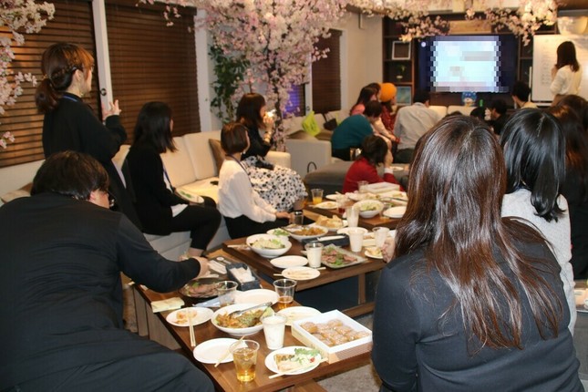 大型テレビに映るゲーム画面を見つめる参加者たち