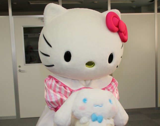 シナモンぬいぐるみに編集部内の様子を見せてあげるキティ