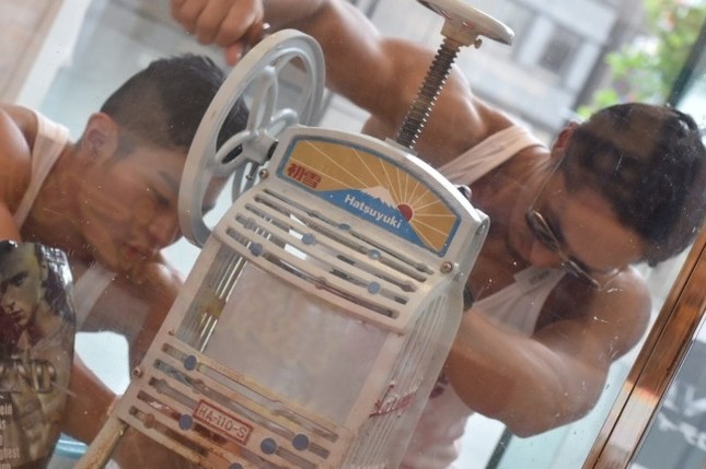 マッチョたちが筋肉を見せつけながらカキ氷を削る