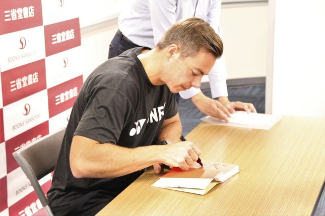 著書にサインをするサーシャさん