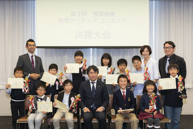 コンテストの審査員委員長の樫尾隆司さん（中央）と決勝大会に参加した小学生たち