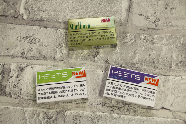 専用たばこスティック「ヒーツ・シトラス・グリーン」（左下）、「ヒーツ・フレッシュ・パープル」（右下）、「マールボロ・ヒートスティック・ブライト・メンソール」（中央上）