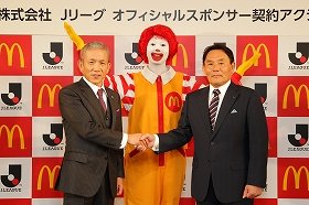 会見で握手を交わす原田泳幸・日本マクドナルド代表取締役会長兼社長兼CEOと大東和美・社団法人日本プロサッカーリーグチェアマン