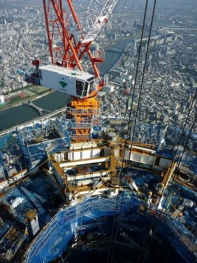 写真は、タワークレーンの作業風景。
