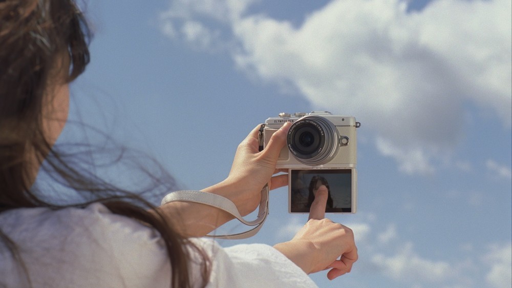 海をバックに、タッチシャッターでセルフィーを撮る
