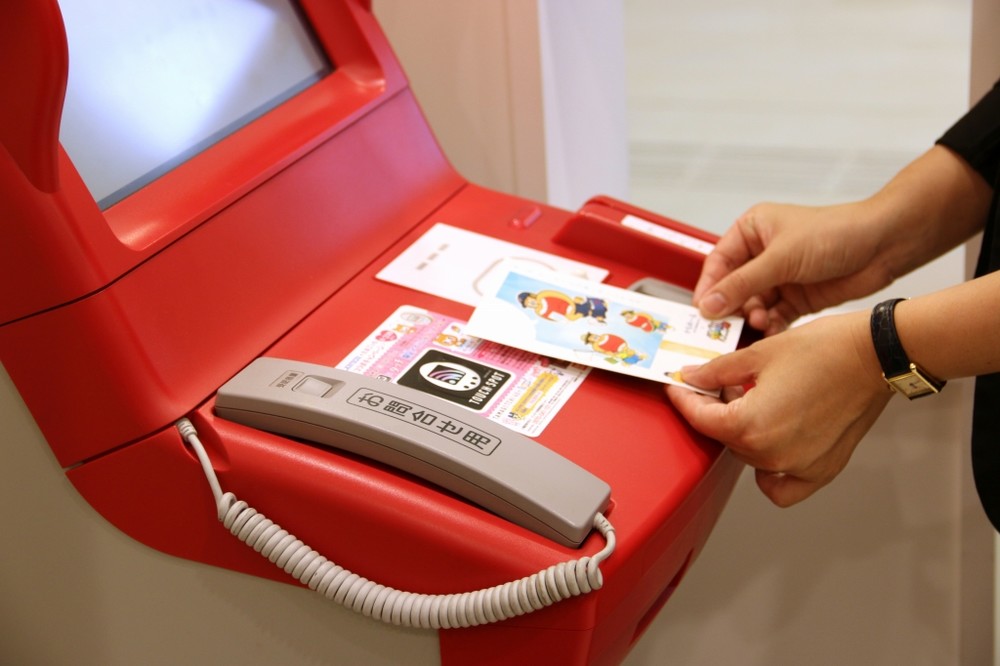 ローソンの「Loppi」にかざす（写真はセレモニー後のデモンストレーション）