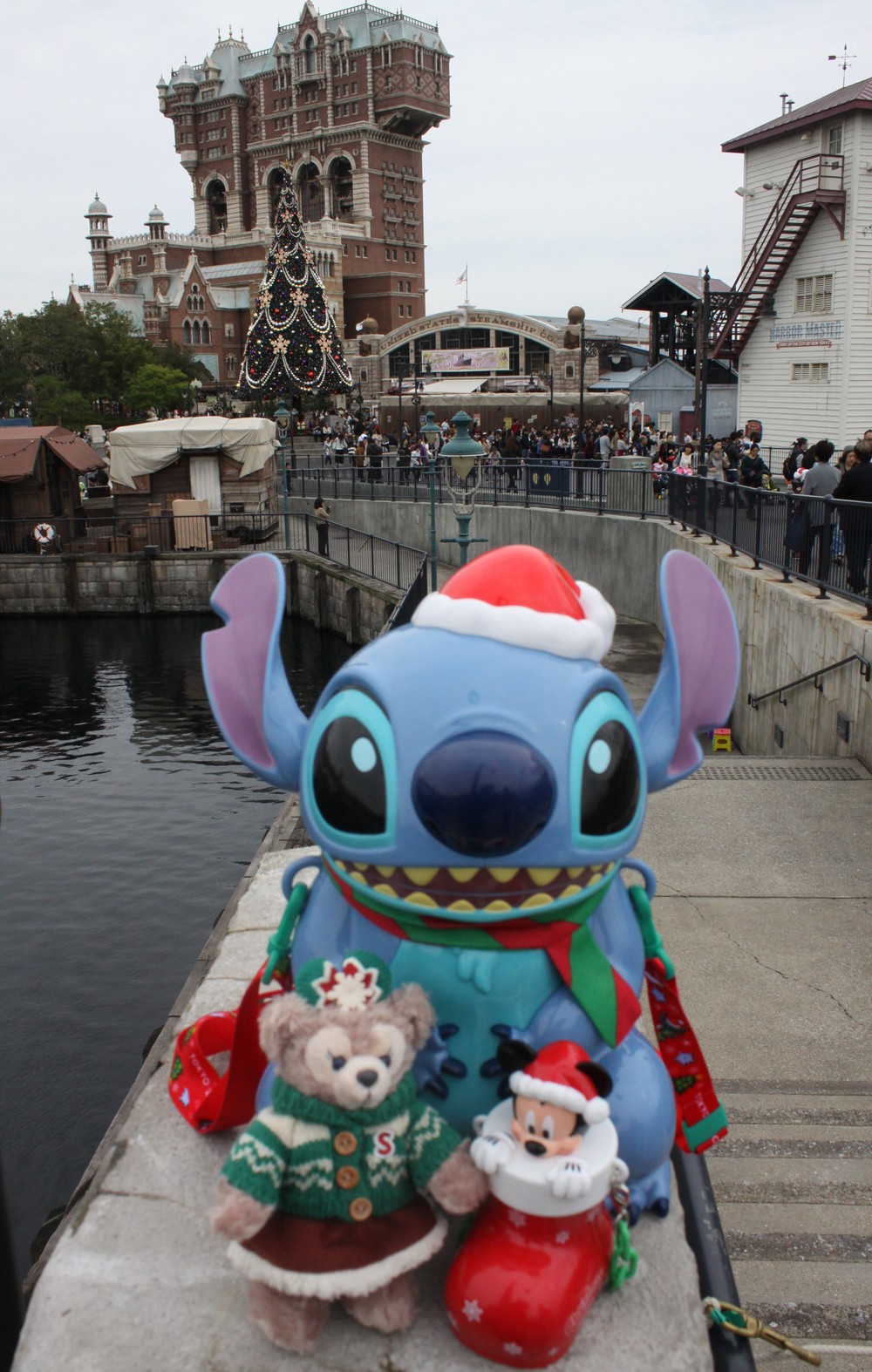 クリスマスのスペシャルグッズの一部。スティッチのバケット付きポップコーン(2100円)や、ミッキーのミニスナックケース付きグミキャンディー、ぬいぐるみバッジ(2000円)