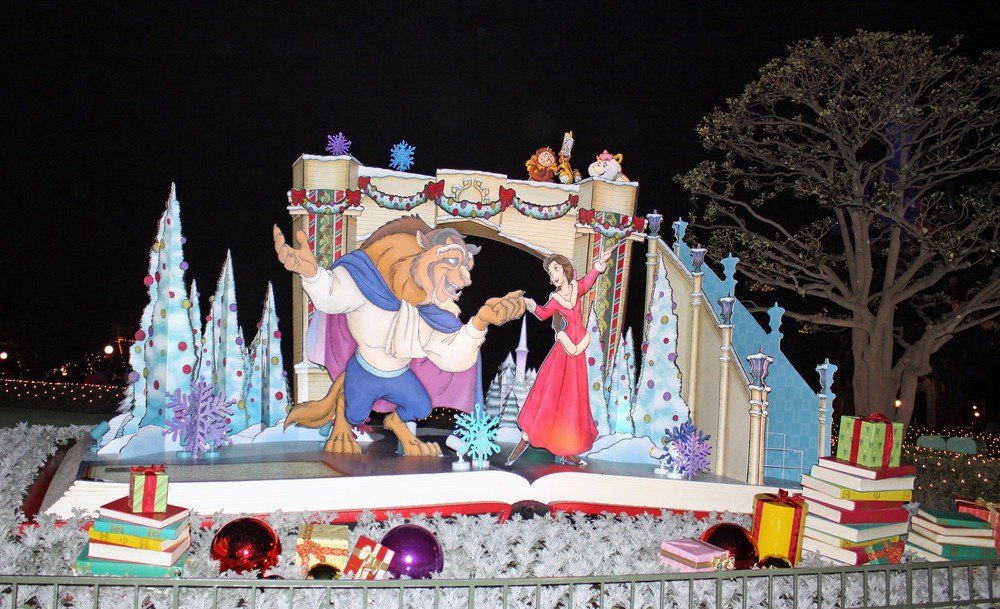 TDL、シンデレラ城前プラザに飾られた「美女野獣」のデコレーション。ベルとビーストがスケートを楽しんでいるシーンの周りにプレゼントの本などが置かれている