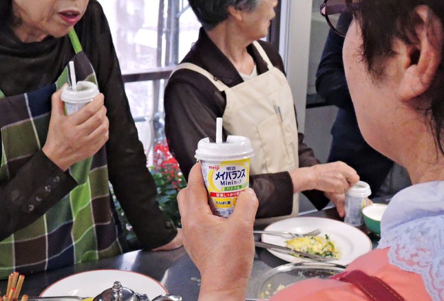 「明治メイバランスMiniカップ」を飲む生徒たち